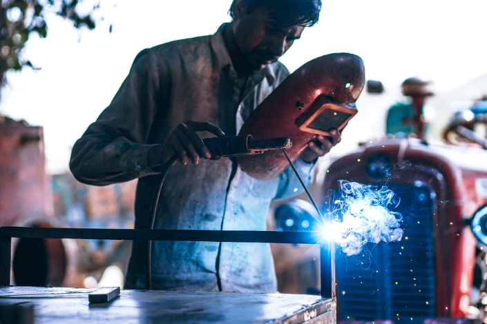 a welder holding a helmet